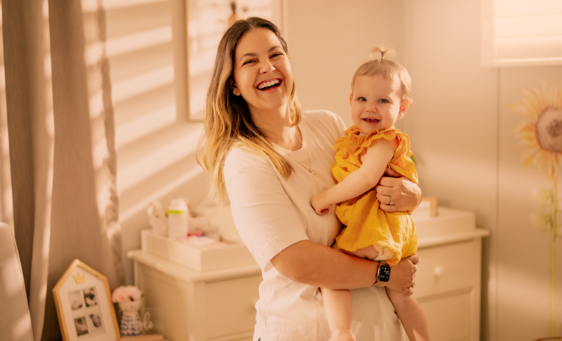 Person smiling holding a baby