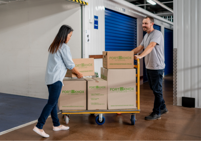 People using a trolley to move Fort Knox Storage boxes