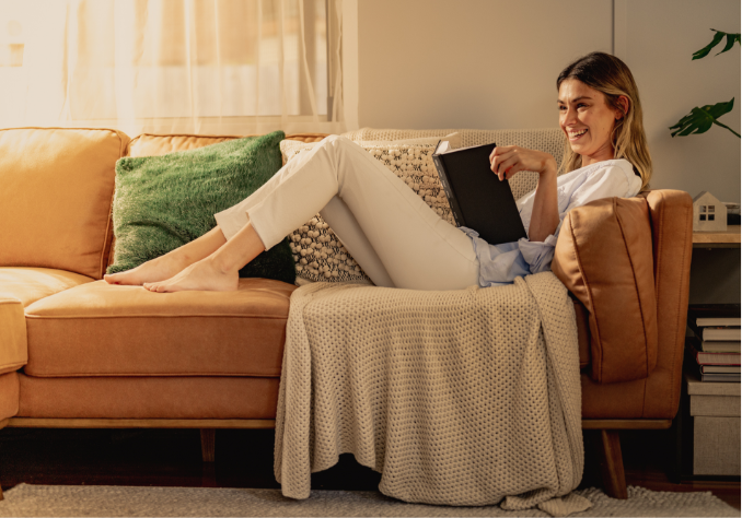 A person sat on a couch reading a book