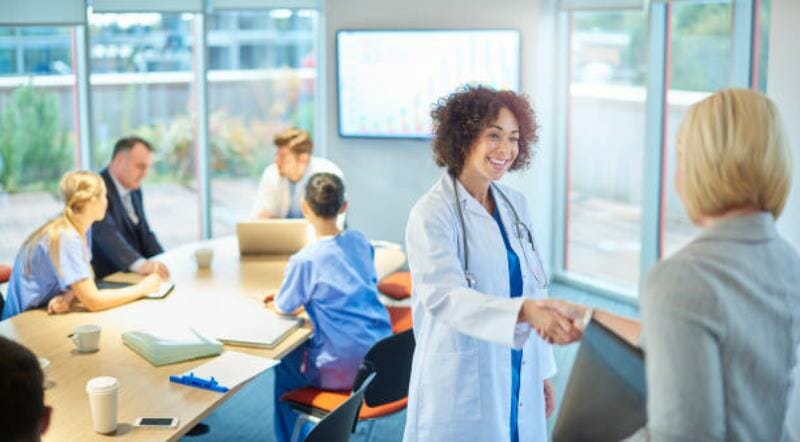 People shaking hands within a boardroom