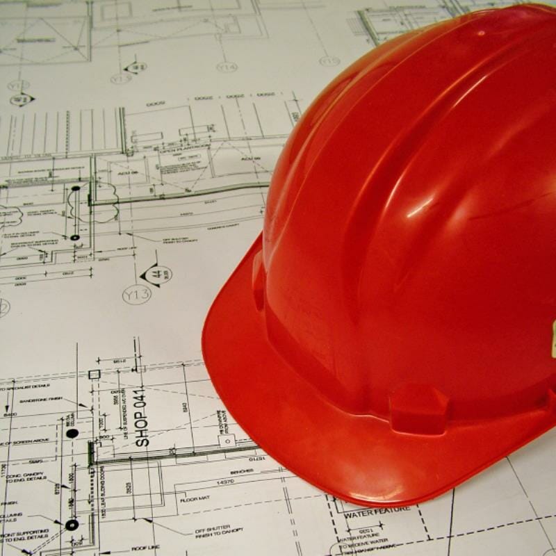 A construction hat resting on blueprints