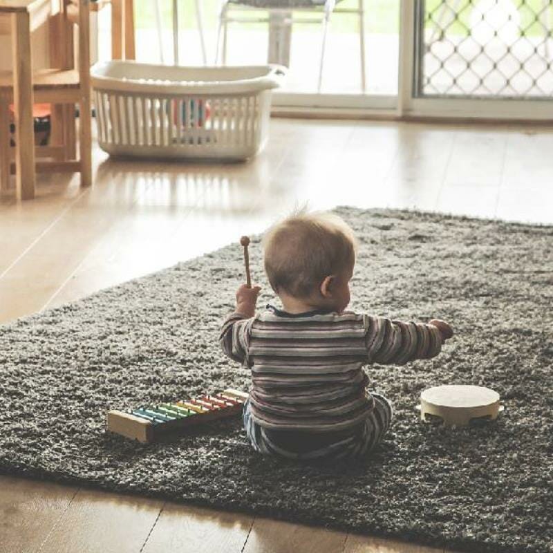 A baby playing with a xylophone